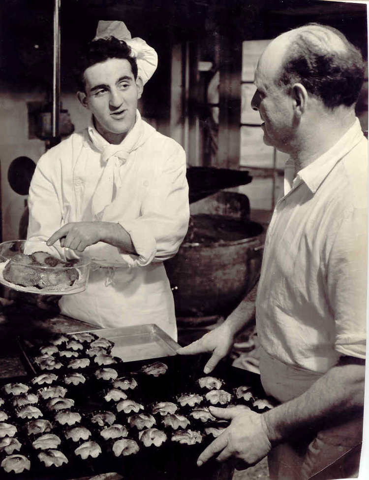 Dave en Meijer Verdooner  <p>David Verdooner aan het werk in de bakkerij van zijn vader Meijer. De foto is waarschijnlijk gemaakt aan het einde van de jaren vijftig. De foto is afkomstig uit het foto archief van David Verdooner.</p>